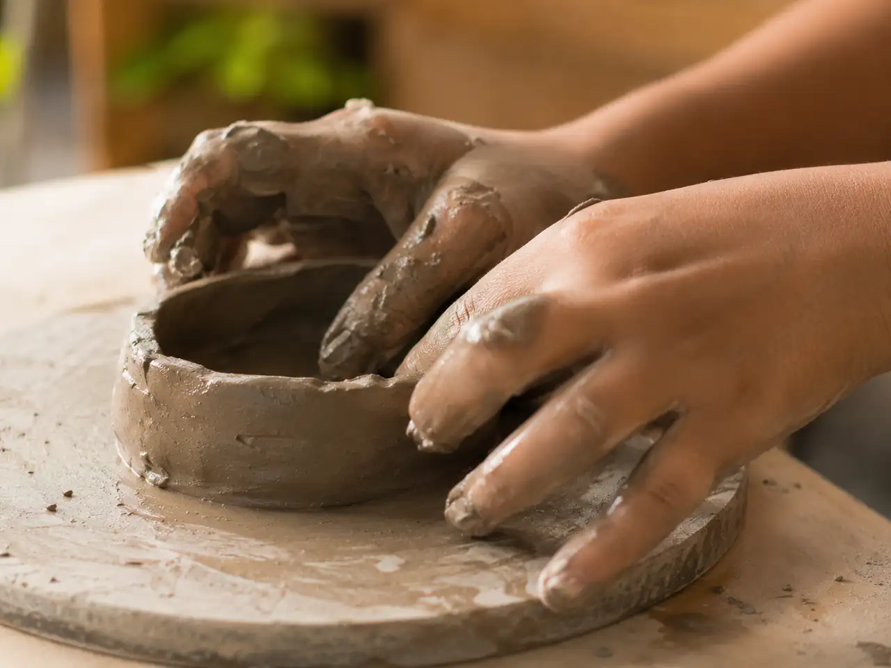 Hands shaping clay at the Wellsprings maker corner